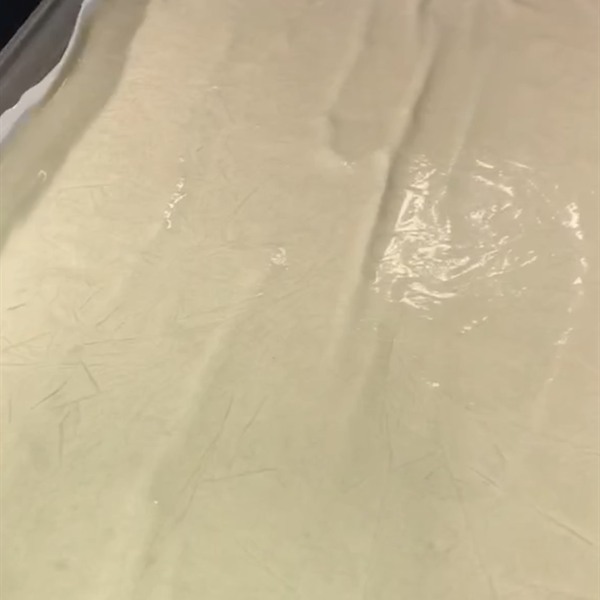 Sheet of pale pressed rosin resting in a black tray