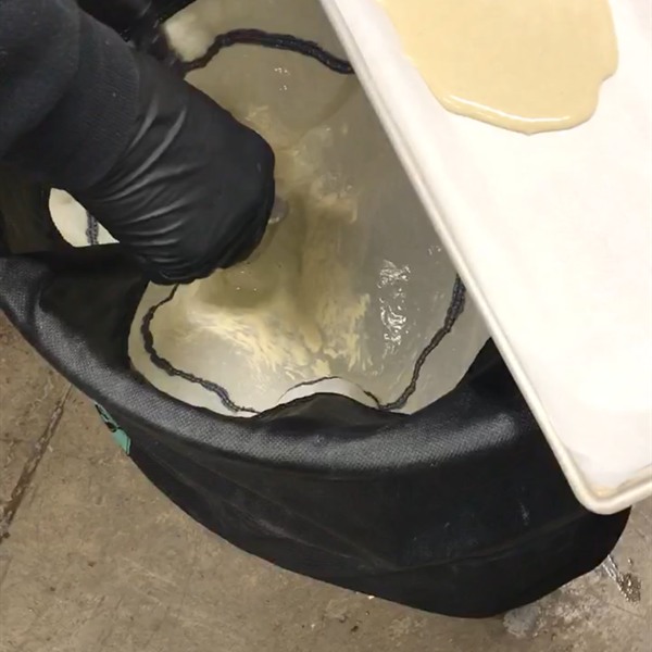 Gloved hand lifting pressed rosin off parchment with a tool