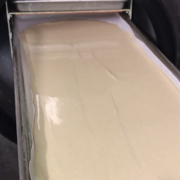 Sheet of pressed rosin being lifted from a steel tray