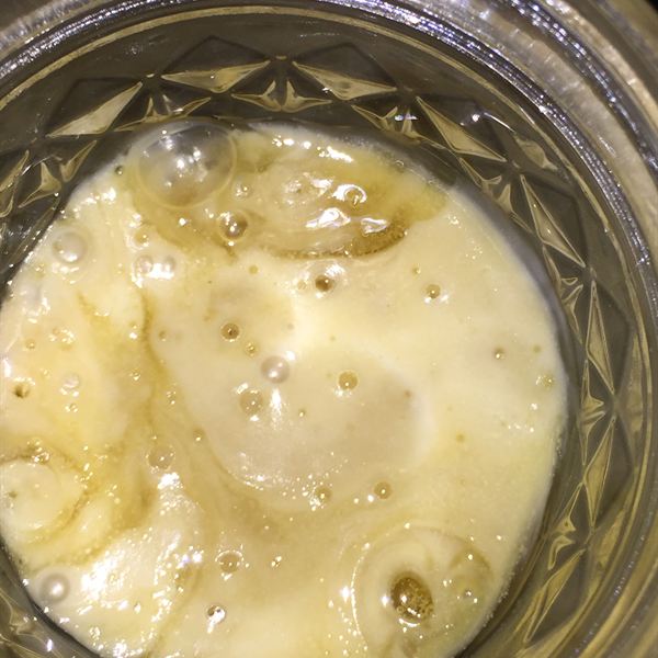 Looking down into a jar of pale solventless rosin badder